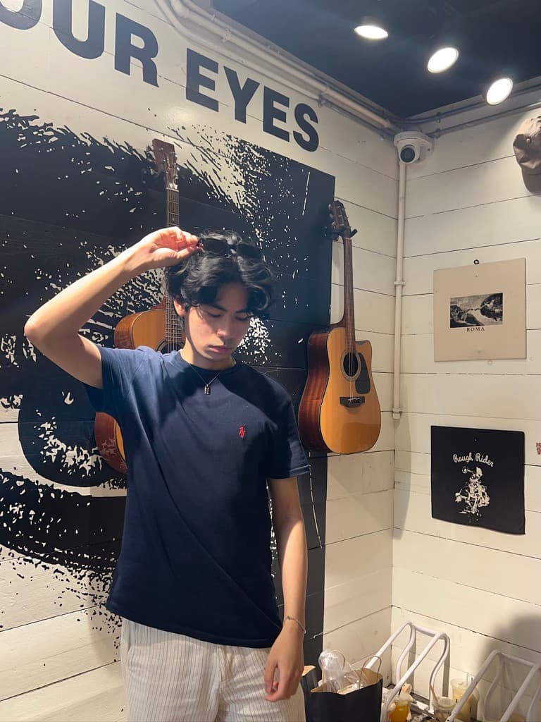 Standing in a room with guitars hanging on the walls