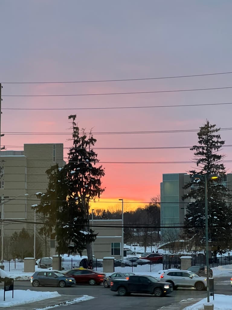 Pink and orange sunset above a snowy street